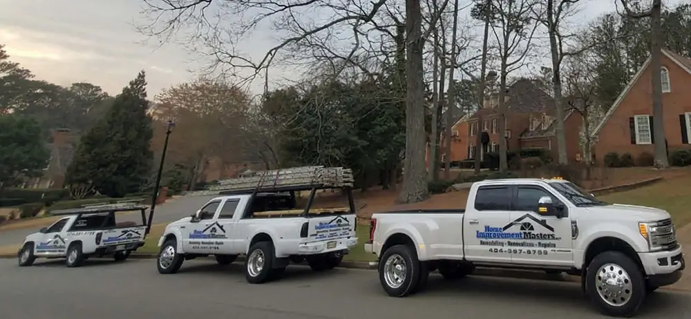 three home improvement master trucks next to house in canton ga