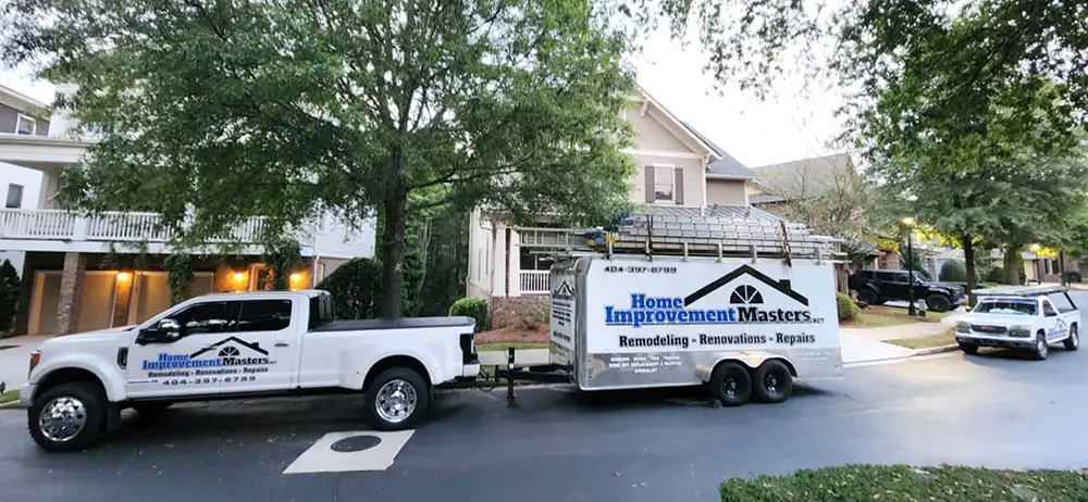 home improvement master trucks and trailer next to two house in canton ga